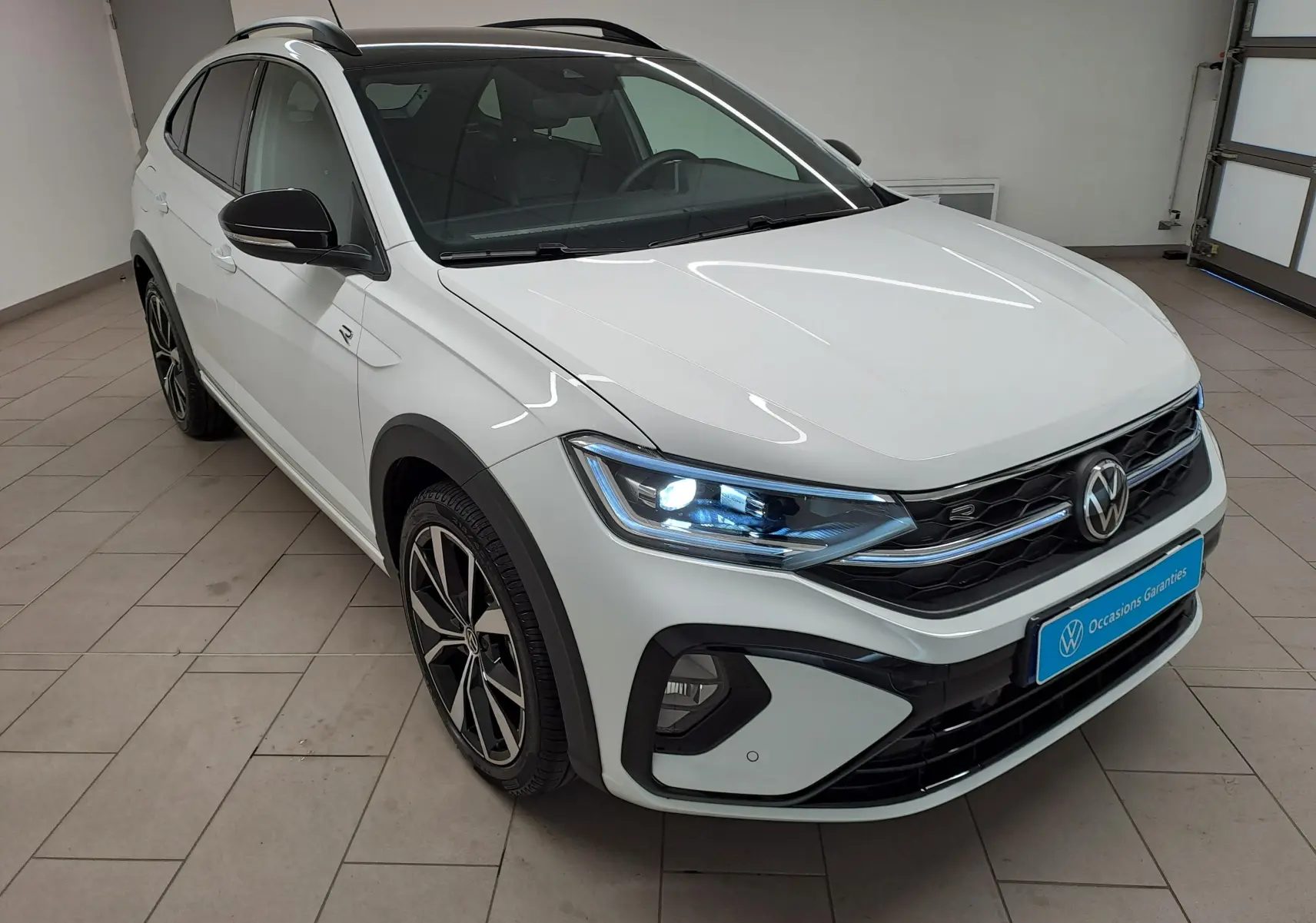 Volkswagen Taigo 1.5 TSI 2025 blanc toit noir, vue 3/4 avant droit avec jantes alliage 18 pouces Misano.