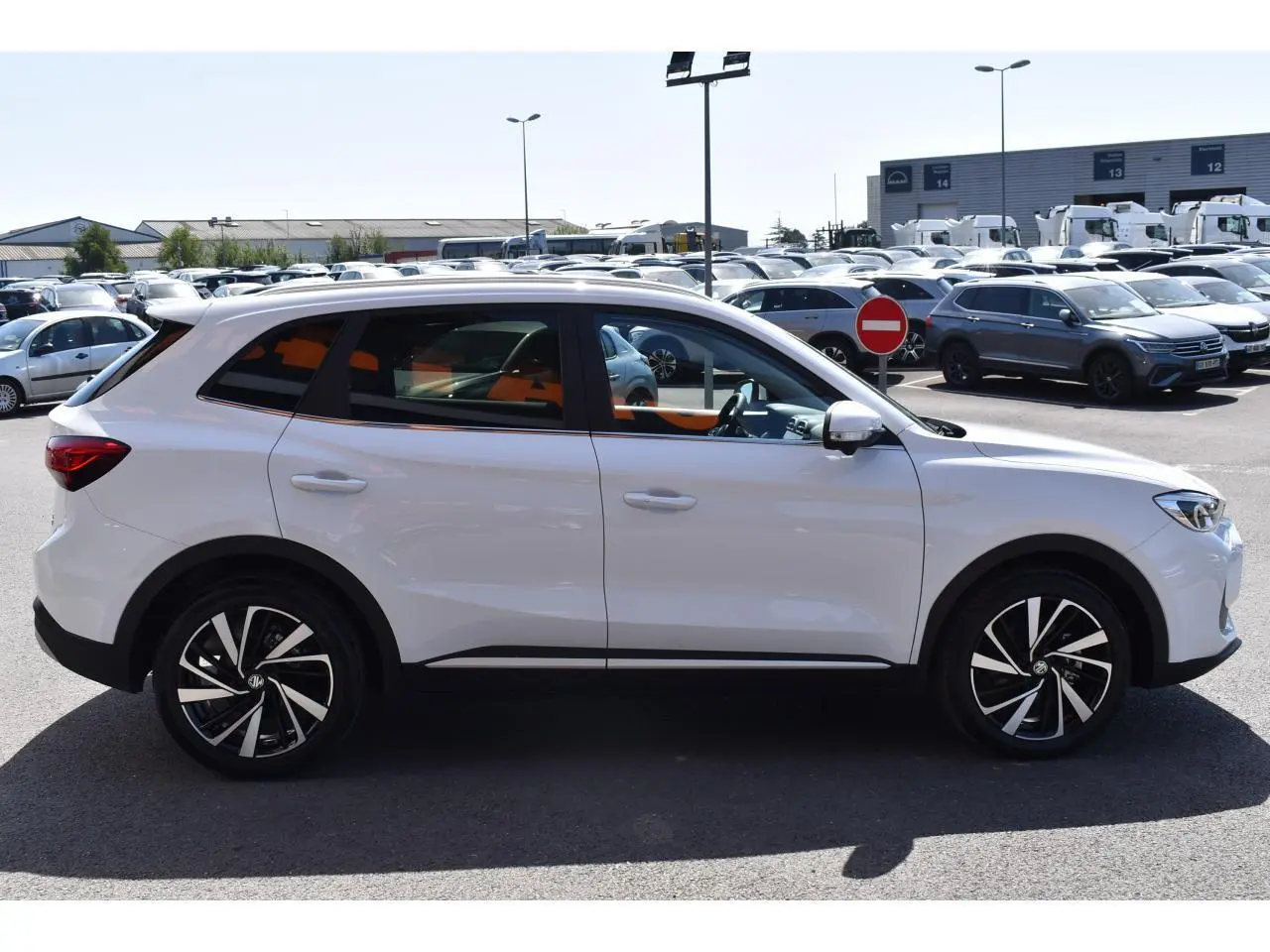 Vue de profil côté gauche d’un MG ZS blanc 2026 avec jantes alliage 18 pouces, version hybride essence Luxury.