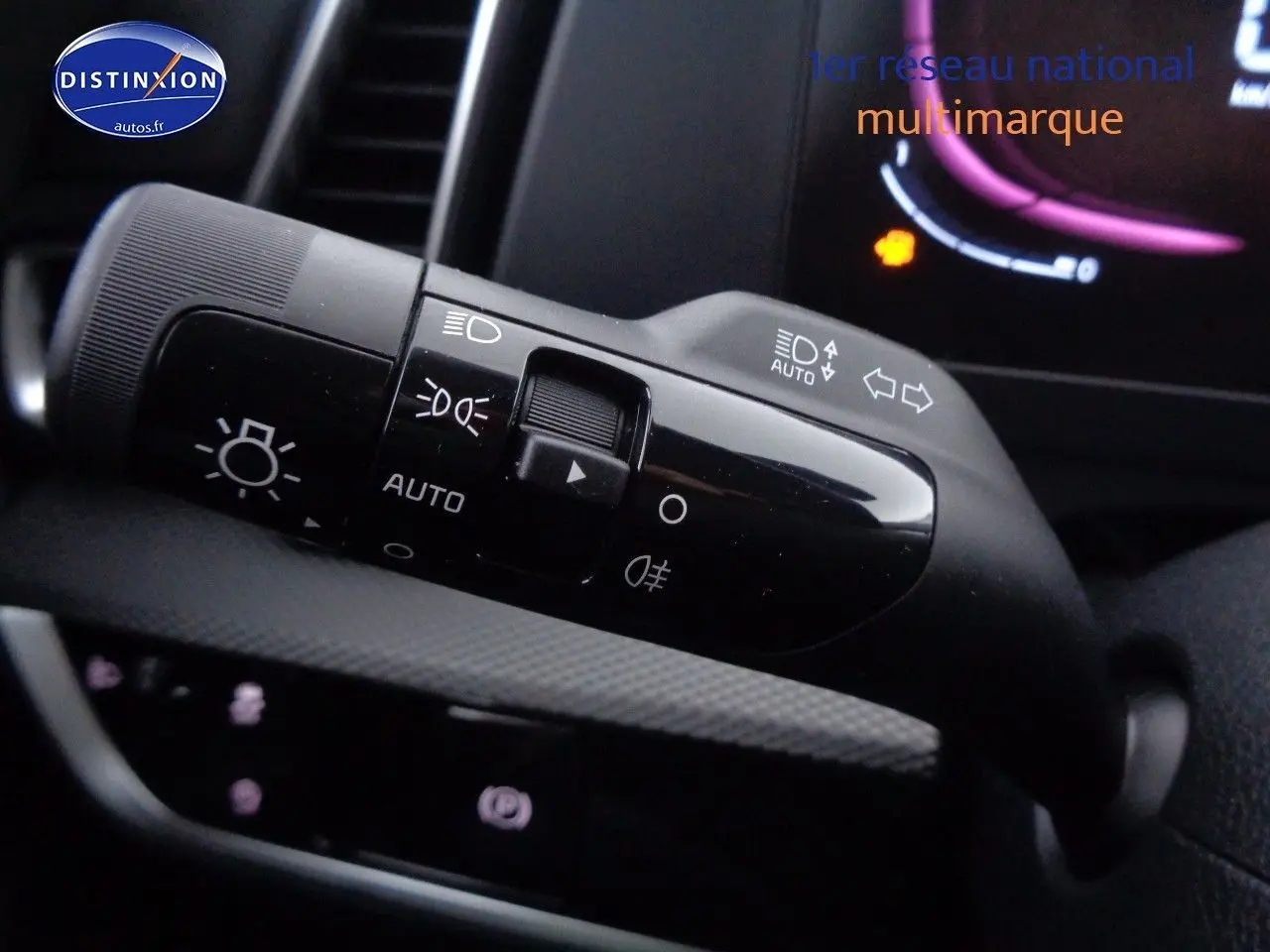 Gros plan sur la commande des phares et clignotants du Kia Sportage 2022, intérieur noir avec affichage numérique.