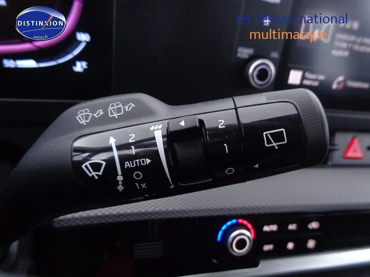 Gros plan sur la commande des essuie-glaces dans l’habitacle d’un KIA Sportage gris acier 2022, avec tableau de bord en arrière-plan.