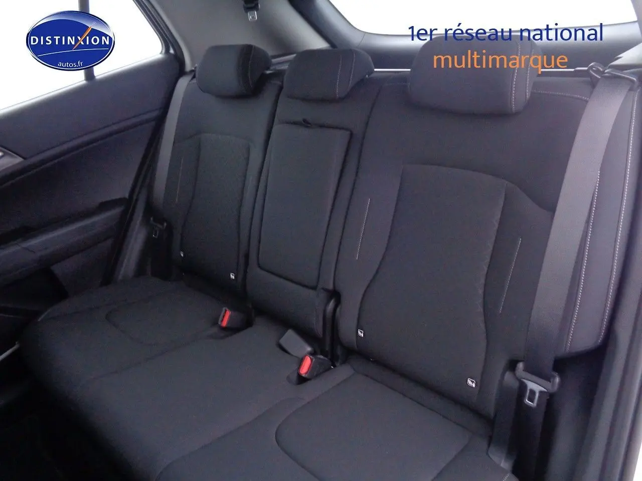 Vue intérieure montrant la banquette arrière en tissu noir du Kia Sportage 2022, avec appuie-têtes et ceinture de sécurité.