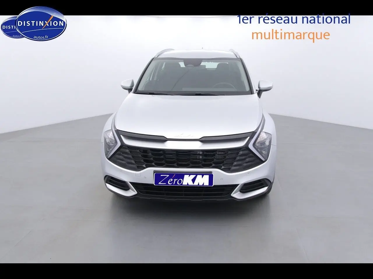 Vue frontale d'un KIA Sportage gris acier métal 2022 avec calandre noire et phares LED en forme de flèche.