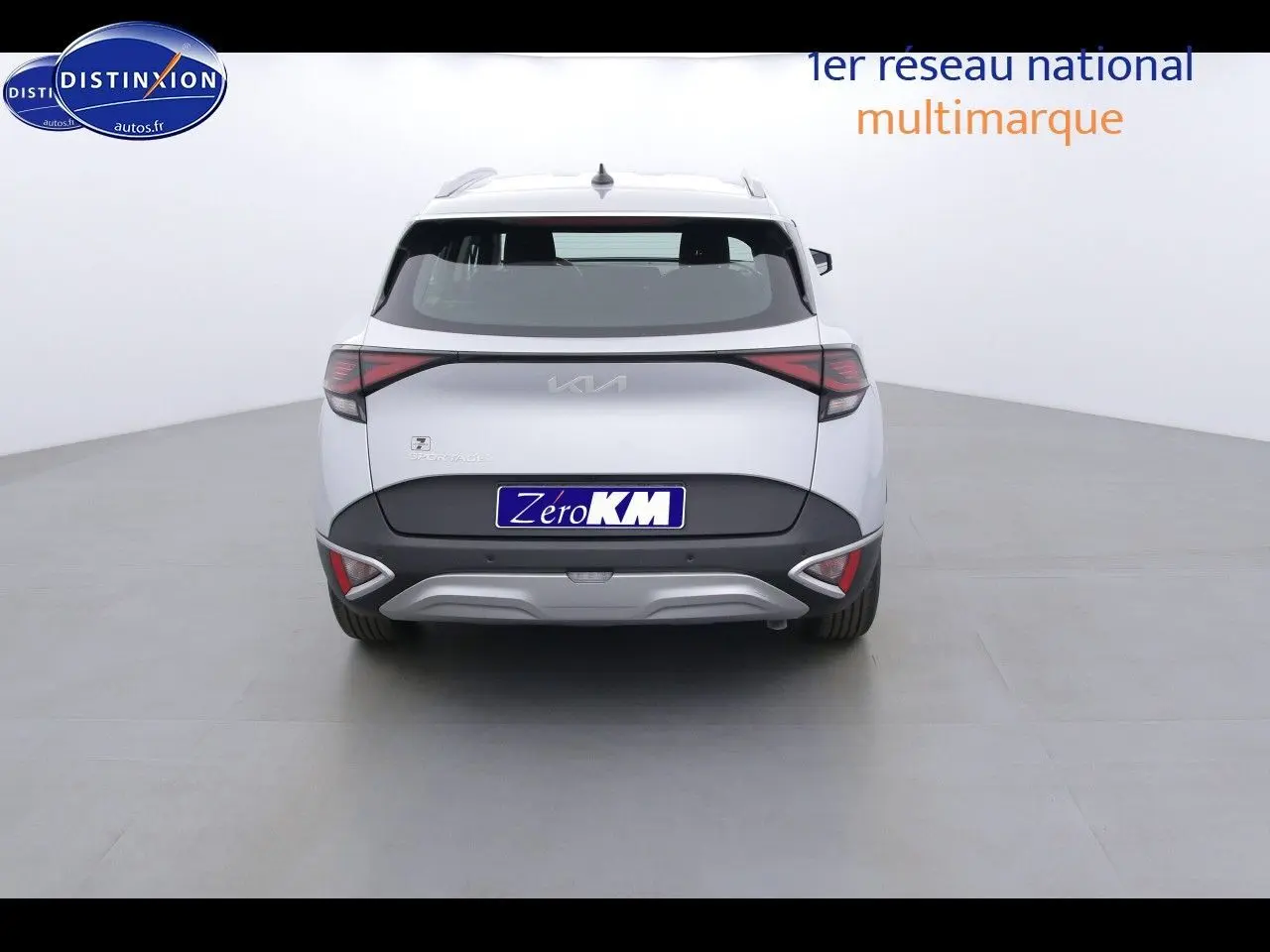 Vue arrière du KIA Sportage gris acier métal 2022 avec feux arrière bicolores et logo central lumineux.