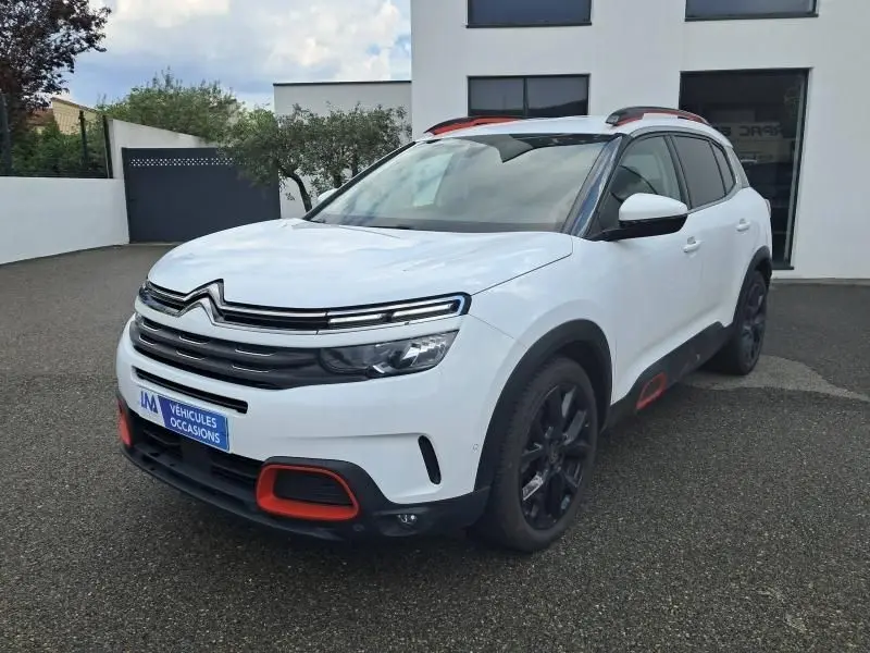 Citroën C5 Aircross blanc vue 3/4 avant droit avec détails rouges sur boucliers et jantes noires.