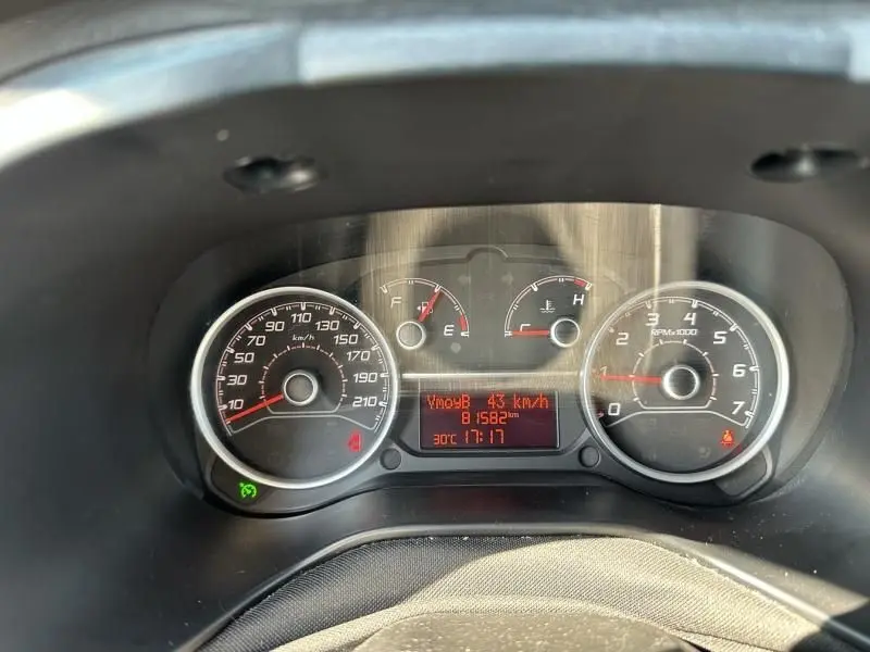 Vue rapprochée du tableau de bord du Fiat Doblo Cargo gris foncé, affichant vitesse, compte-tours et jauges.