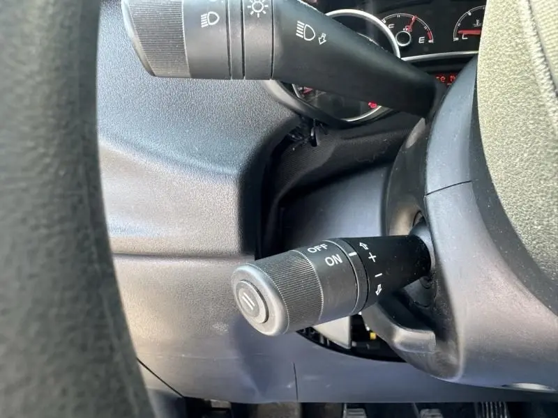 Gros plan sur la commande de régulateur de vitesse du tableau de bord du Fiat Doblo Cargo gris foncé 2021.