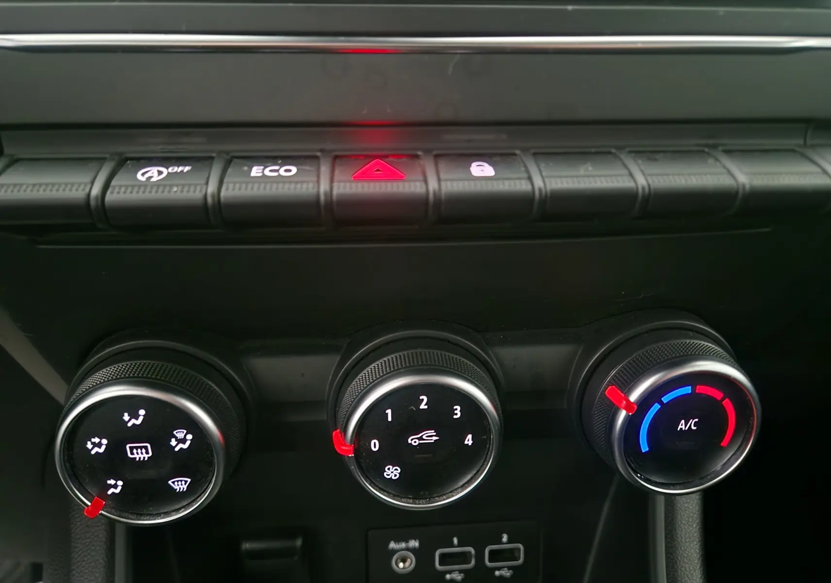 Gros plan sur les commandes de climatisation manuelle et les boutons de fonction du tableau de bord du Renault Captur gris Highland.