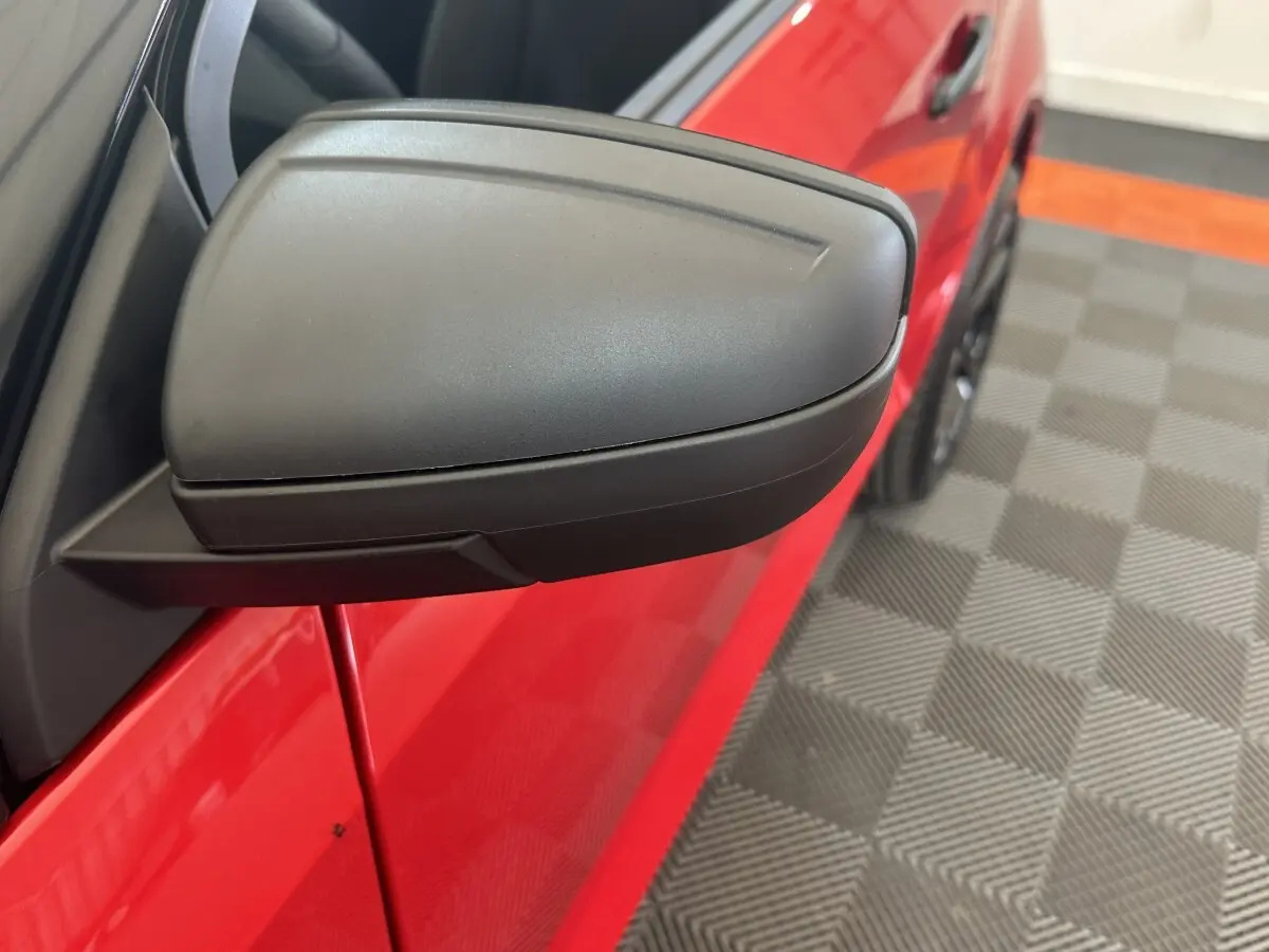 Gros plan sur le rétroviseur caméra côté conducteur d'une Aixam Ambition 0.5 City Sport rouge, vue côté gauche.