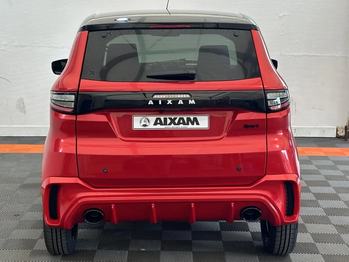 Vue arrière d'une Aixam Ambition 0.5 City Sport rouge 2026 avec diffuseur sport et feux arrière noirs.