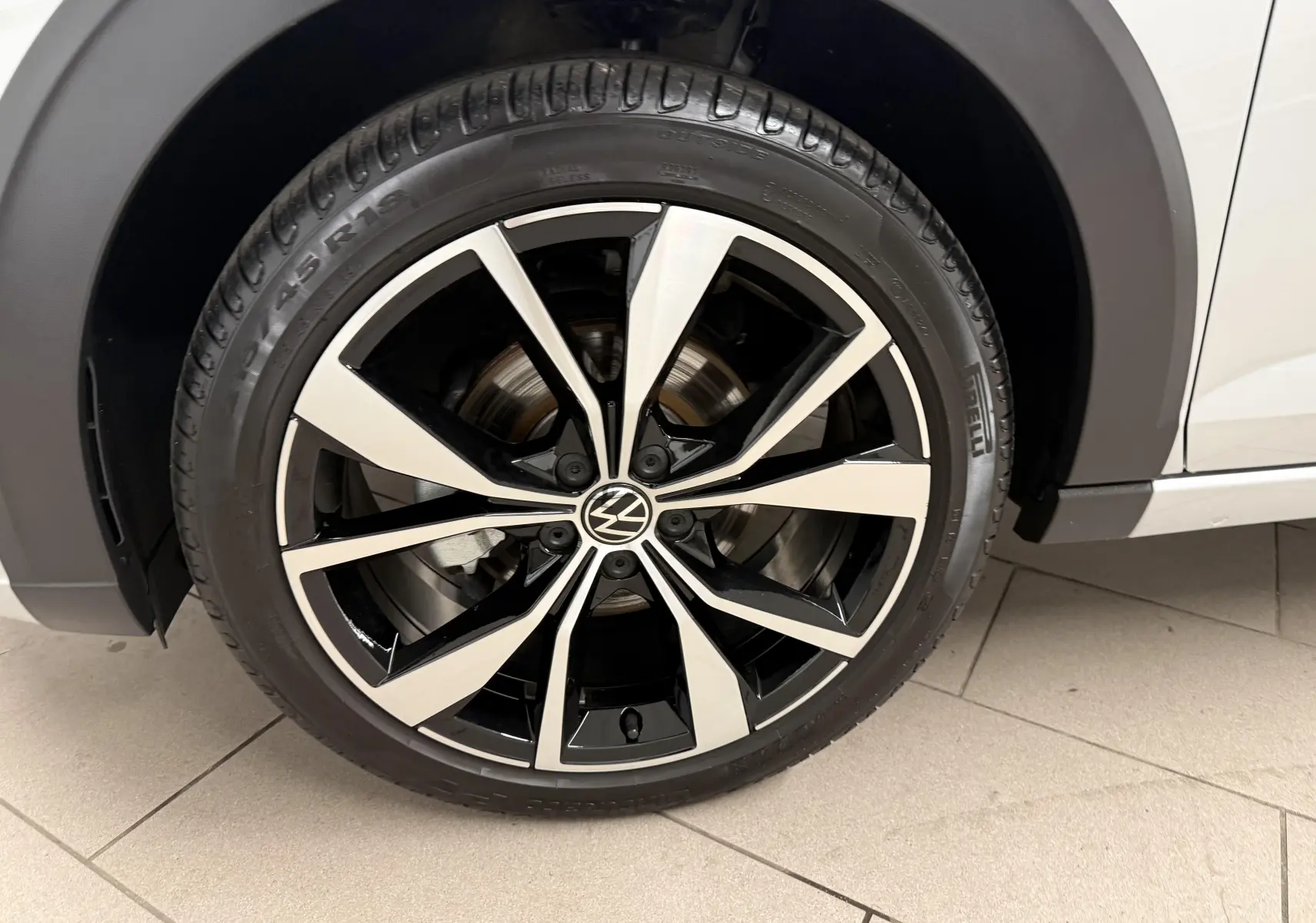 Gros plan sur la jante alliage 18 pouces bicolore Misano du côté gauche d’un Volkswagen Taigo argent avec toit noir.