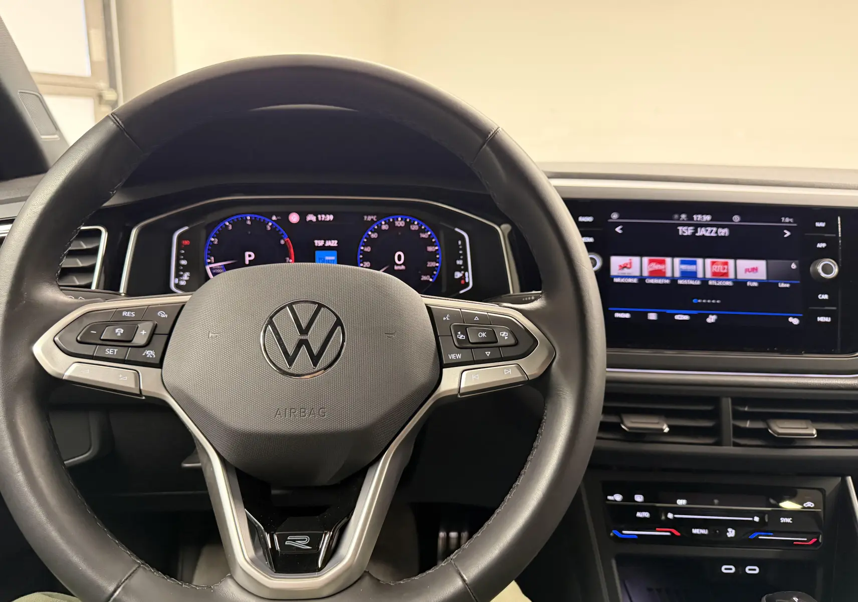 Vue intérieure centrée sur le volant multifonction d'une Volkswagen Taigo 1.5 TSI R-Line avec tableau de bord numérique.