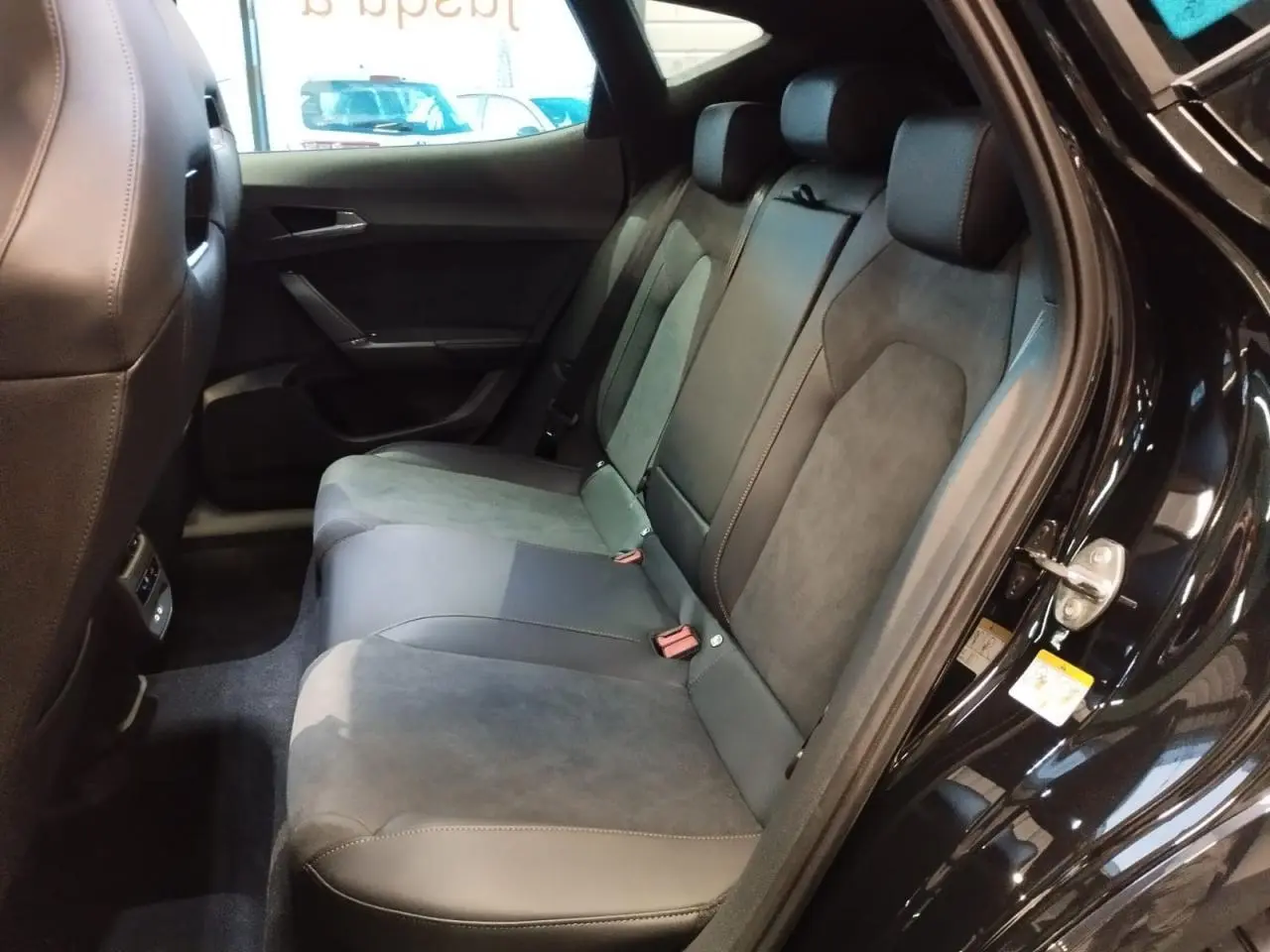 Vue intérieure arrière côté droit du CUPRA Formentor noir métal, sièges baquets bimatière suédine et cuir noir avec surpiqûres cuivrées.