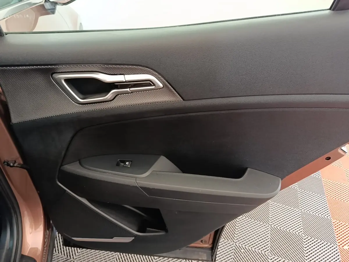 Vue rapprochée de la porte côté conducteur beige du KIA SPORTAGE 2022, avec poignée argentée et commande de vitre.