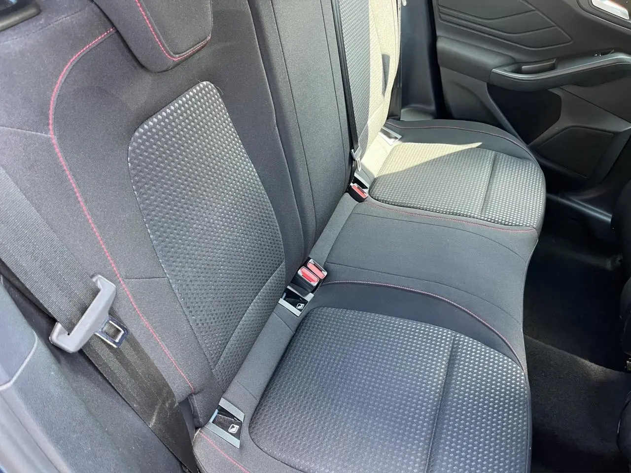 Vue intérieure des sièges arrière noirs avec surpiqûres rouges de la Ford Focus SW 2025, version ST Line X.