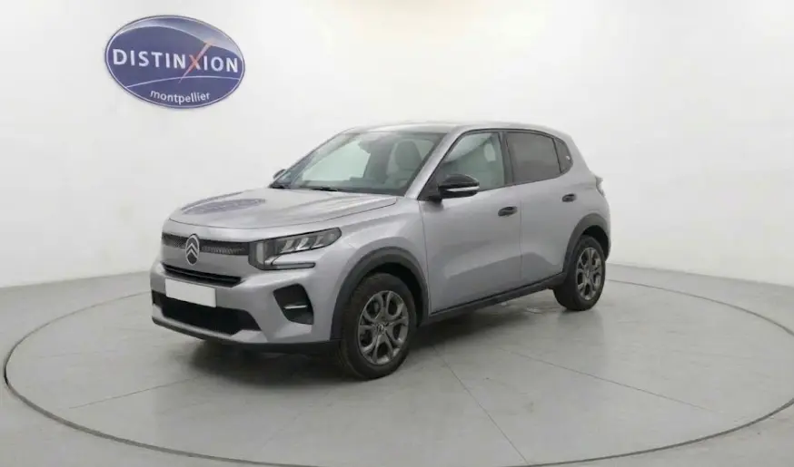 Citroën C3 Turbo 100 ch 2025 gris foncé vue 3/4 avant droit avec calandre moderne et jantes spécifiques.