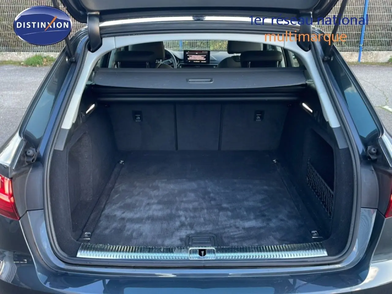 Coffre ouvert vu de l'arrière d'une Audi A4 Avant gris Manhattan, montrant un espace de chargement propre et spacieux.