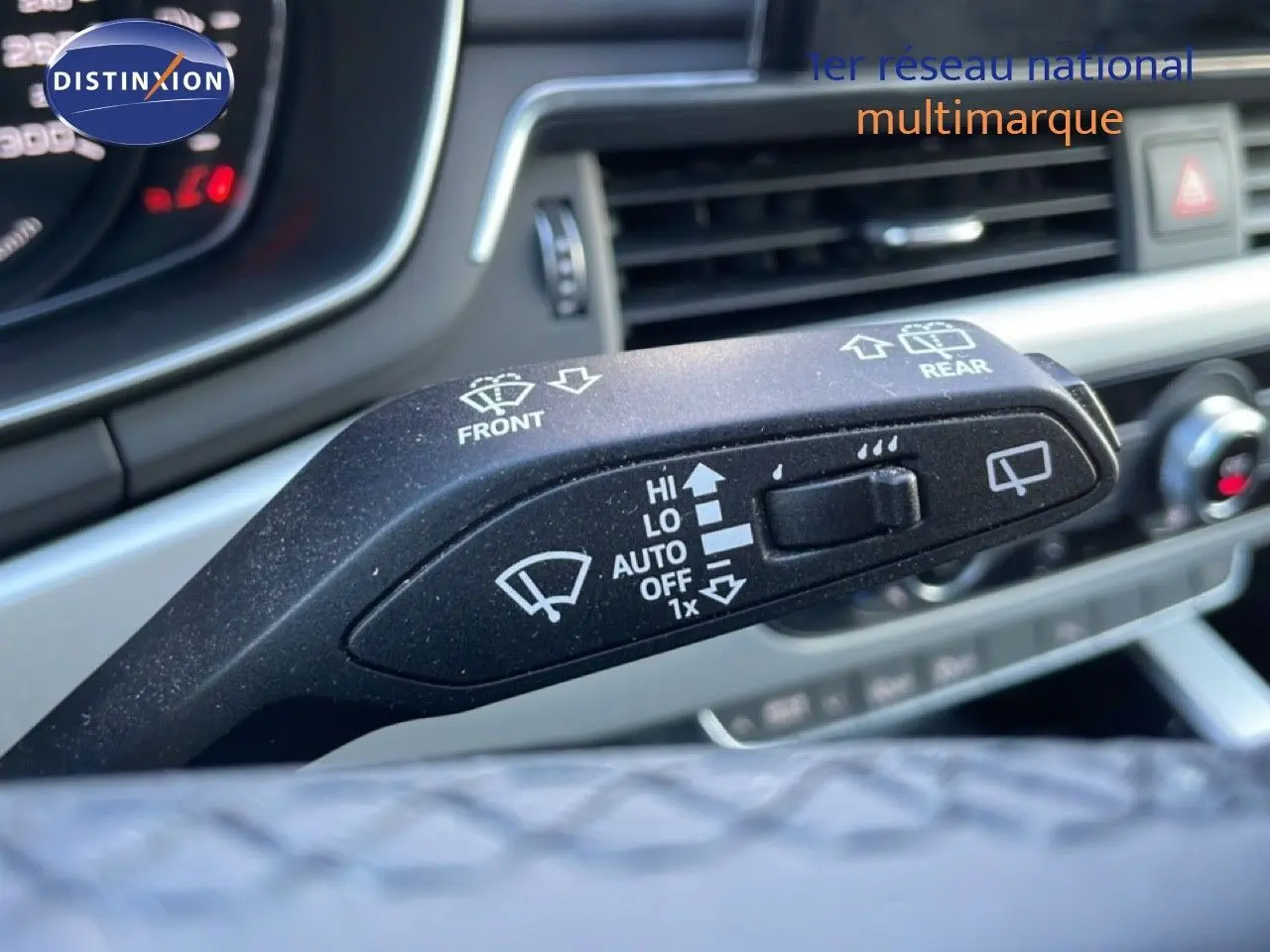 Gros plan sur le commodo d'essuie-glace de l'Audi A4 Avant gris Manhattan, avec tableau de bord et aérateurs en arrière-plan.