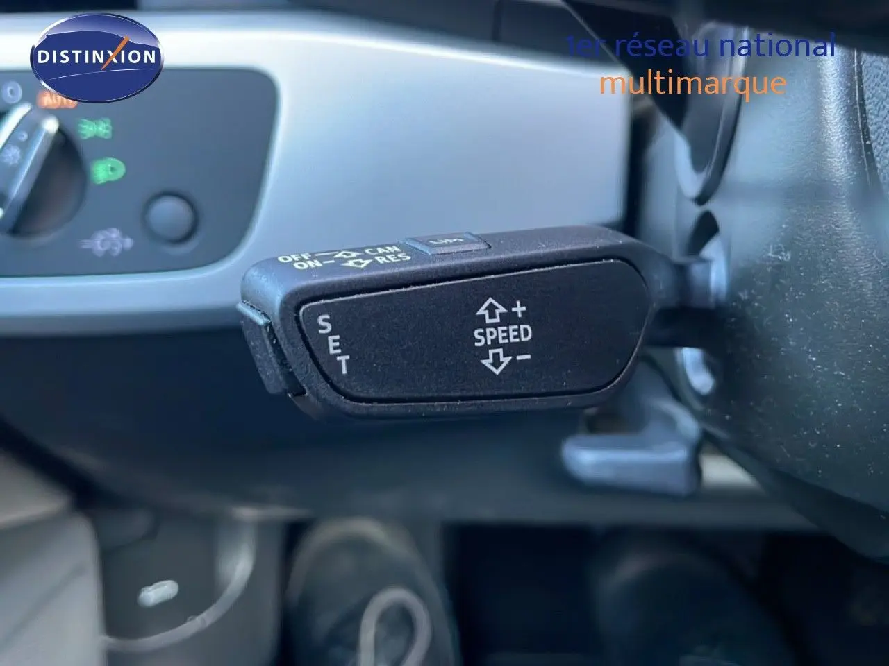 Gros plan sur la commande de régulateur de vitesse au volant d'une Audi A4 Avant gris Manhattan, intérieur visible.