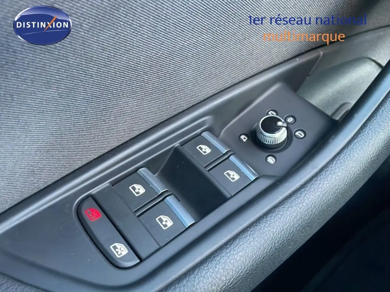 Gros plan sur les commandes des vitres électriques et rétroviseurs sur la porte côté gauche d'une Audi A4 Avant gris Manhattan.