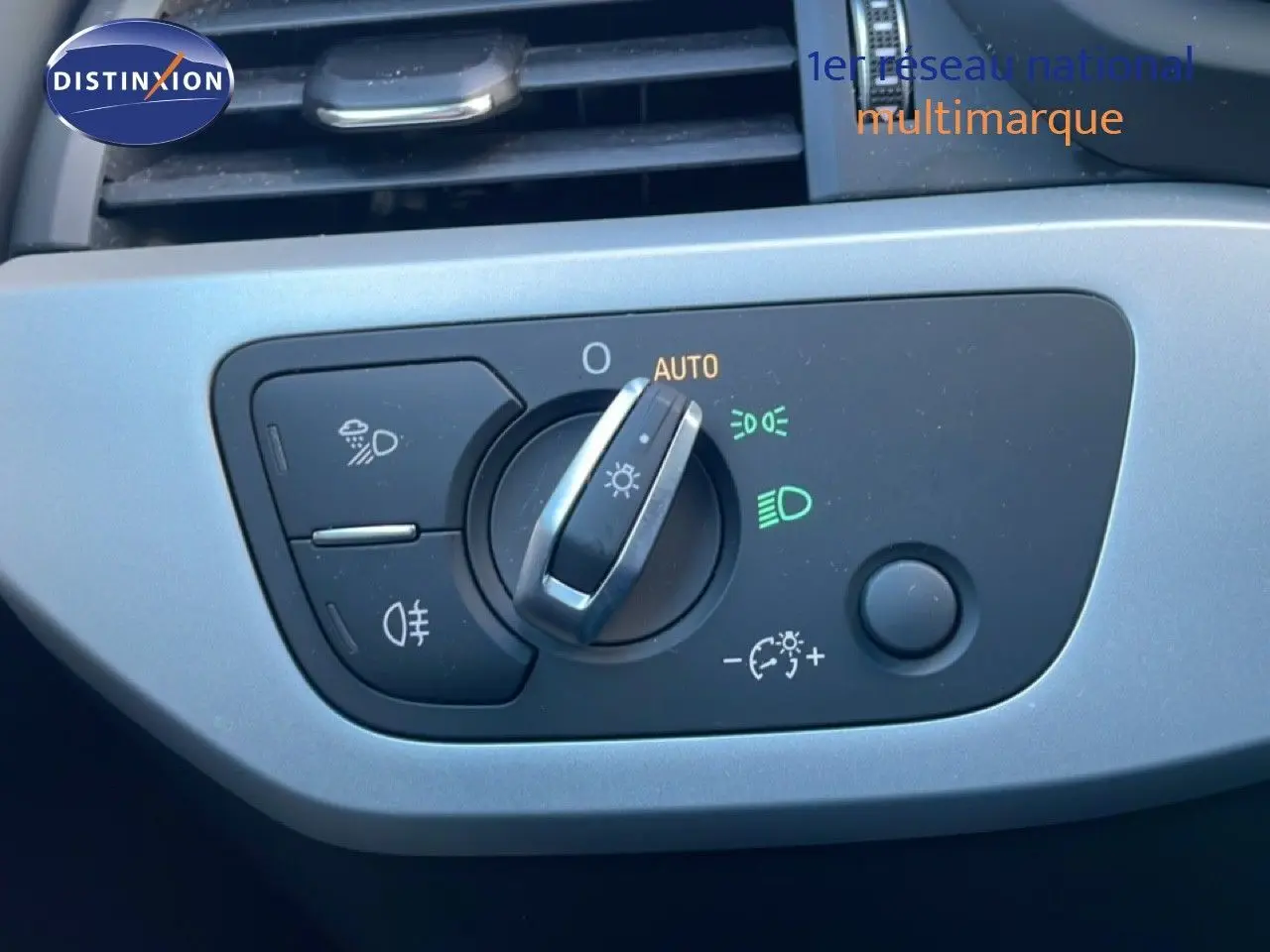 Gros plan sur la commande des phares de l'Audi A4 Avant 2021, finition Business Line, avec éclairage automatique activé.