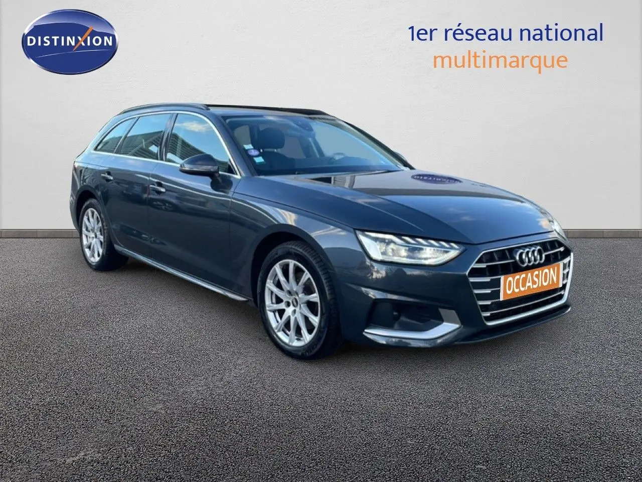 Audi A4 Avant gris Manhattan vue 3/4 avant droit avec calandre distinctive et feux LED allumés.