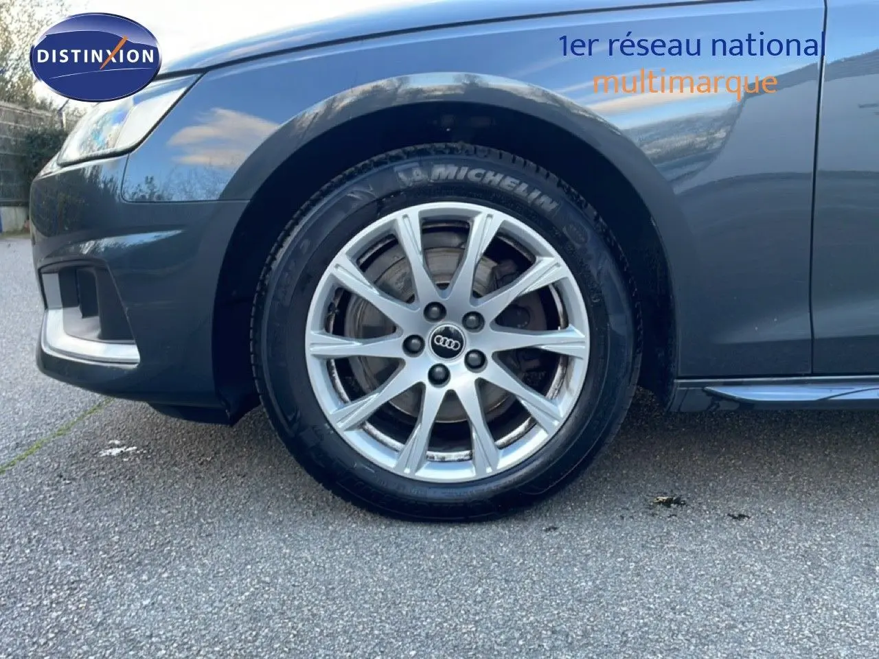 Gros plan sur la roue avant gauche d'une Audi A4 Avant gris Manhattan, mettant en valeur la jante en alliage et le pneu Michelin.