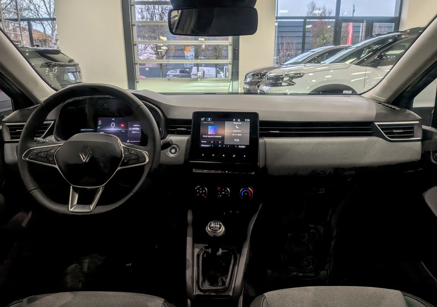 Tableau de bord intérieur de la Renault Clio V gris Rafale, vue frontale avec écran tactile et volant multifonction.