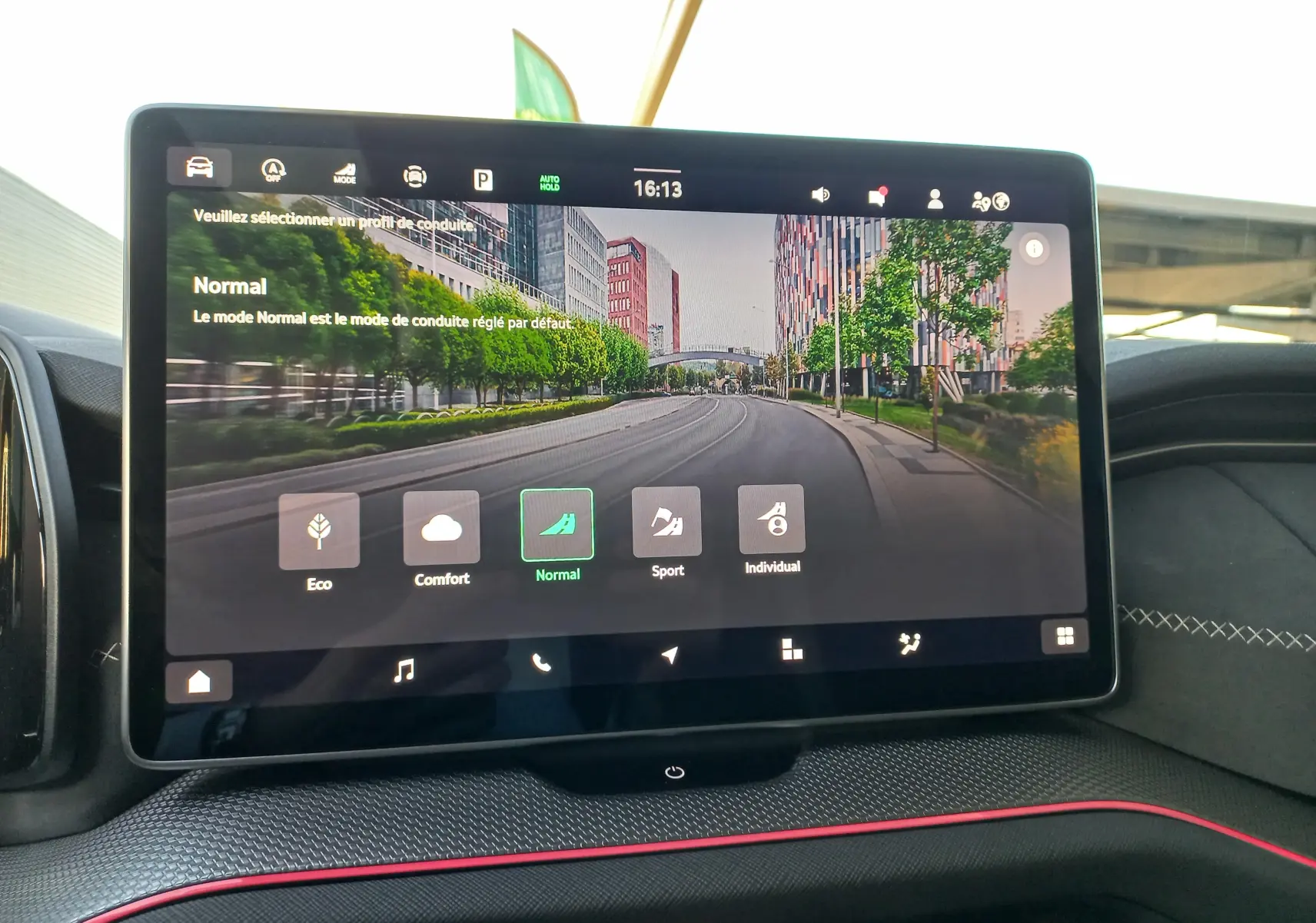 Écran tactile central du Skoda Kodiaq 2024 affichant les modes de conduite dans un intérieur avec surpiqûres blanches et liseré rouge.