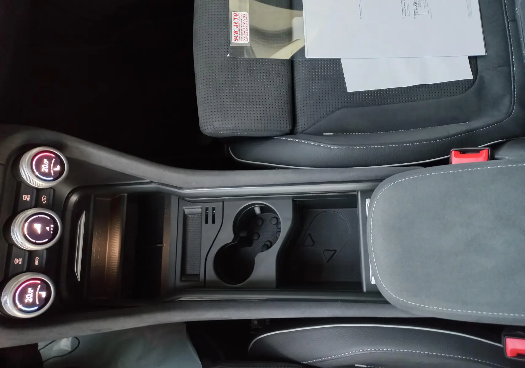 Vue plongeante sur la console centrale et sièges noirs du Skoda Kodiaq Bleu RS avec commandes climatisation et porte-gobelets.