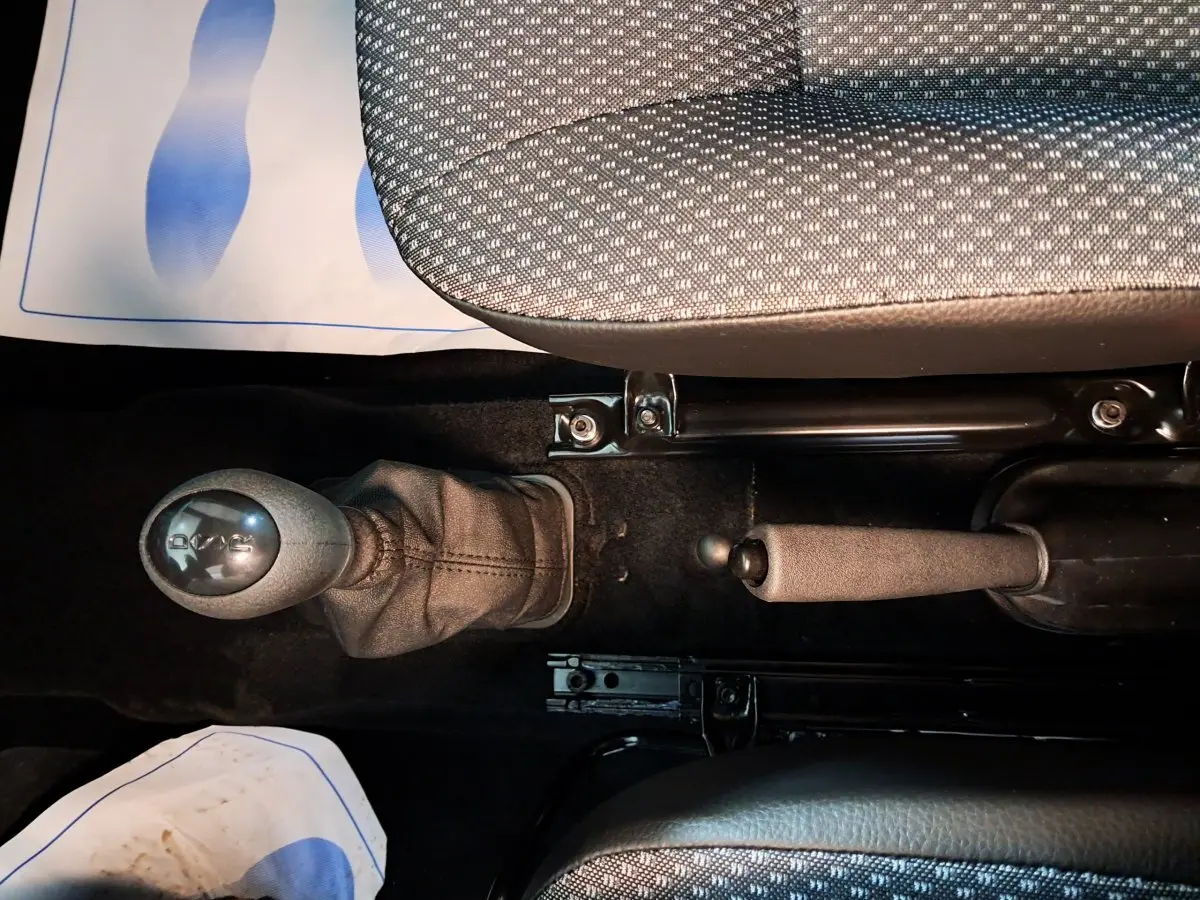 Vue intérieure en plongée sur le levier de vitesse automatique et frein à main de l'AIXAM MINAUTO E chic 2026.