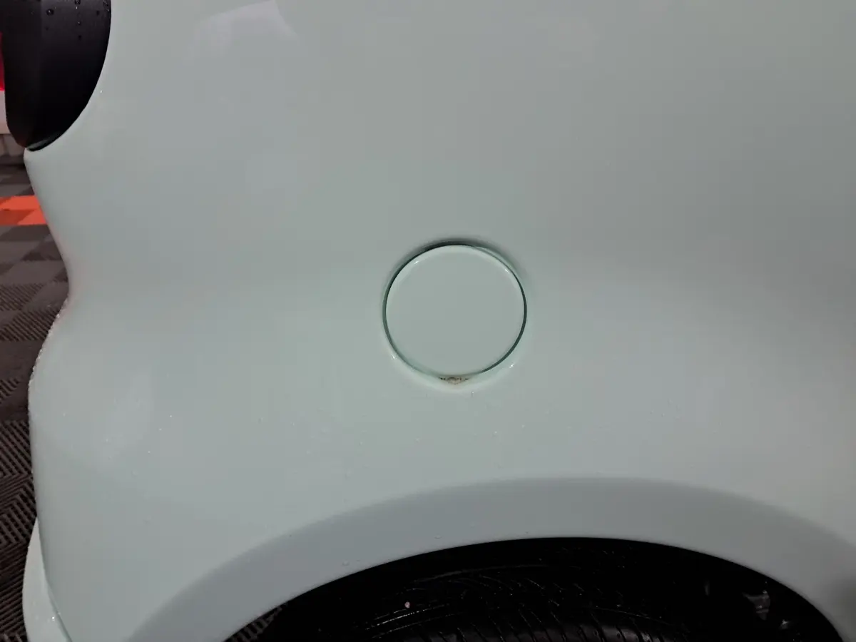 Gros plan sur la trappe de recharge côté gauche d'une Aixam Minauto E chic 2026 verte électrique.