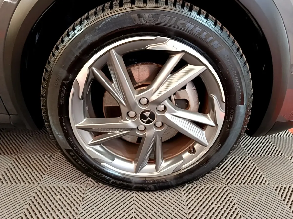 Gros plan sur la roue avant droite avec jante alliage argentée du DS7 Crossback E-TENSE gris foncé.