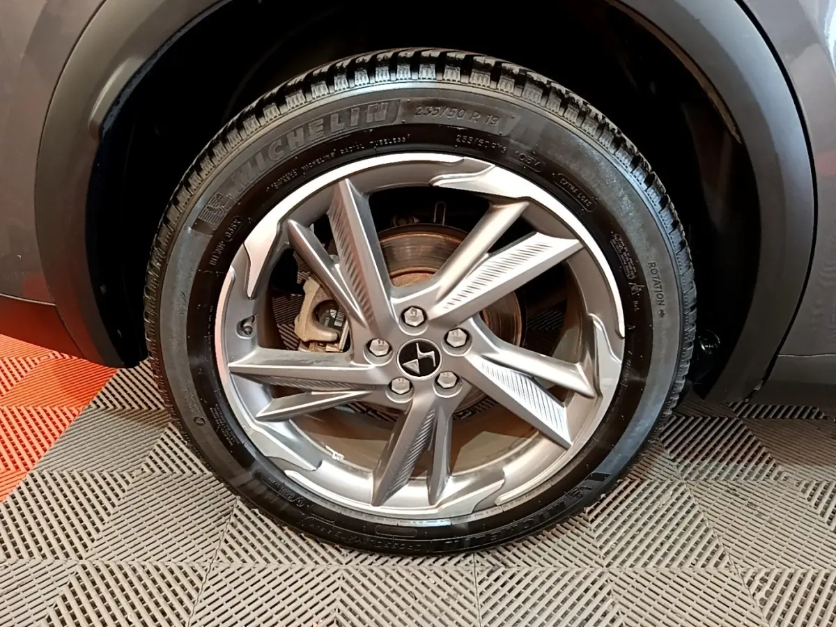 Gros plan sur la roue avant droite gris foncé du DS7 Crossback E-TENSE 4x4 300 RIVOLI avec jante alliage distinctive.