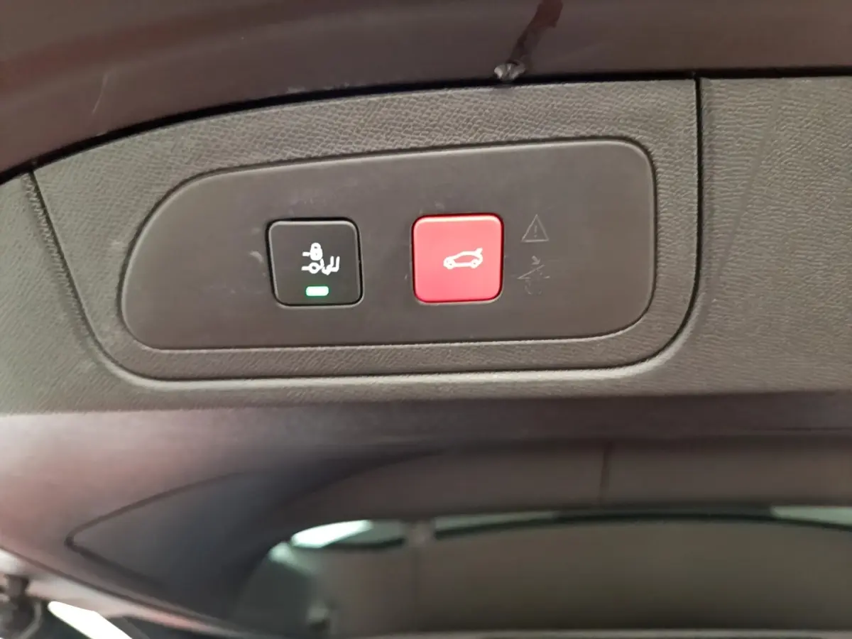 Gros plan sur les boutons de commande du coffre électrique dans l’habitacle du DS7 Crossback gris foncé.