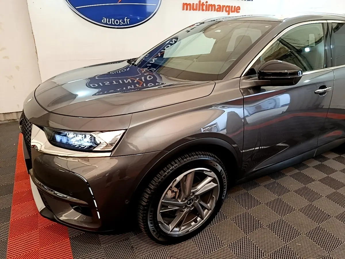 Vue 3/4 avant droit du DS7 Crossback E-TENSE 4x4 300 gris foncé avec phares LED et jantes alliage distinctives.