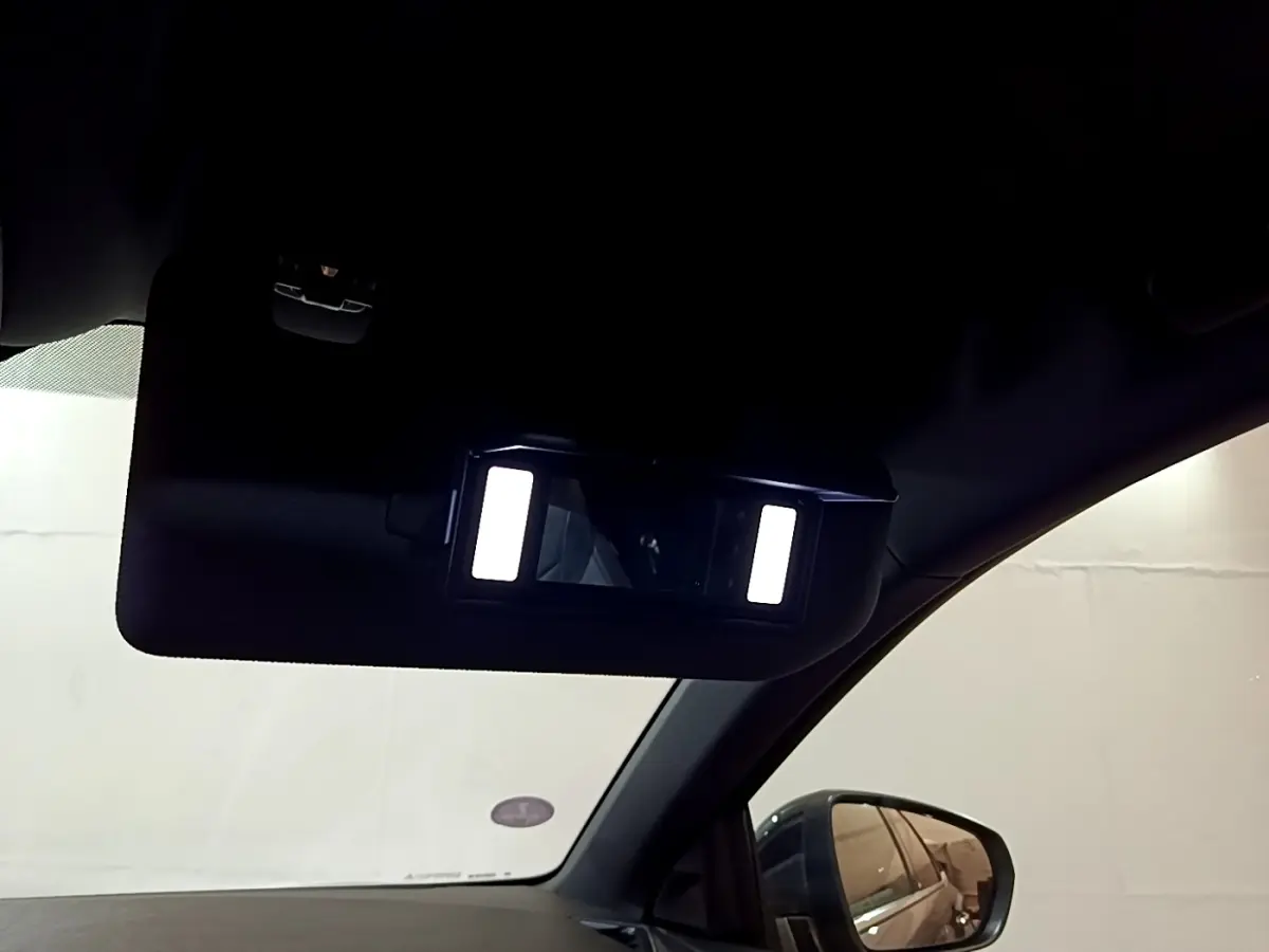 Détail du miroir de courtoisie éclairé côté conducteur dans l’habitacle d’un DS7 Crossback gris foncé.