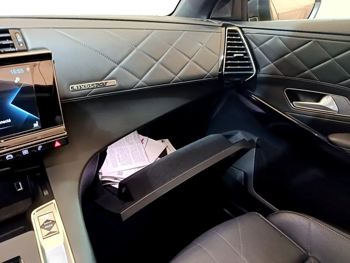 Intérieur côté passager du DS7 Crossback E-TENSE 4x4 300 Rivoli 2021, montrant boîte à gants ouverte et tableau de bord cuir noir matelassé.