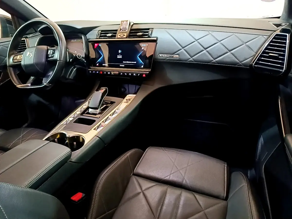Vue intérieure côté conducteur du DS7 Crossback E-TENSE 4x4 300 Rivoli 2021, tableau de bord cuir matelassé noir et écran tactile central.