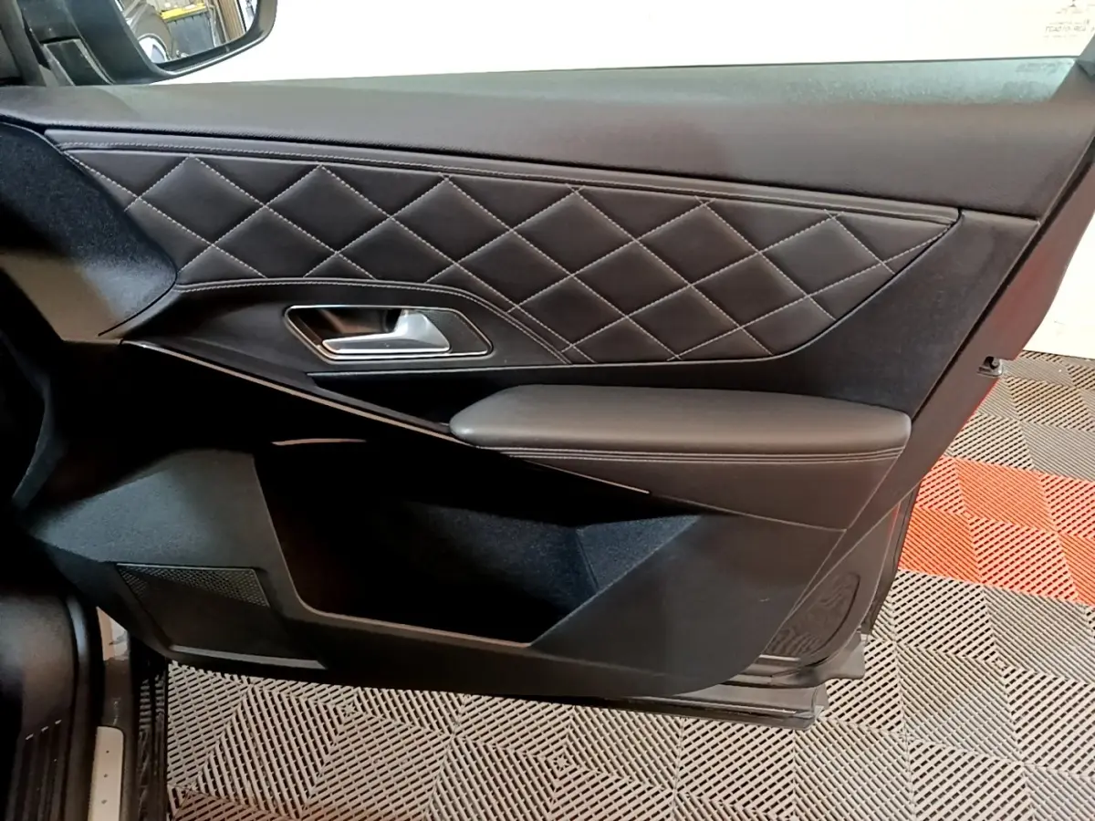 Vue intérieure du panneau de porte côté gauche en cuir noir matelassé du DS7 Crossback E-TENSE 4x4 gris foncé.