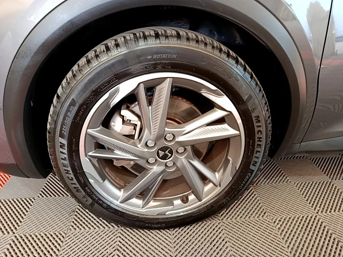 Gros plan sur la roue arrière droite d’un DS7 Crossback E-TENSE gris foncé avec pneu Michelin visible.