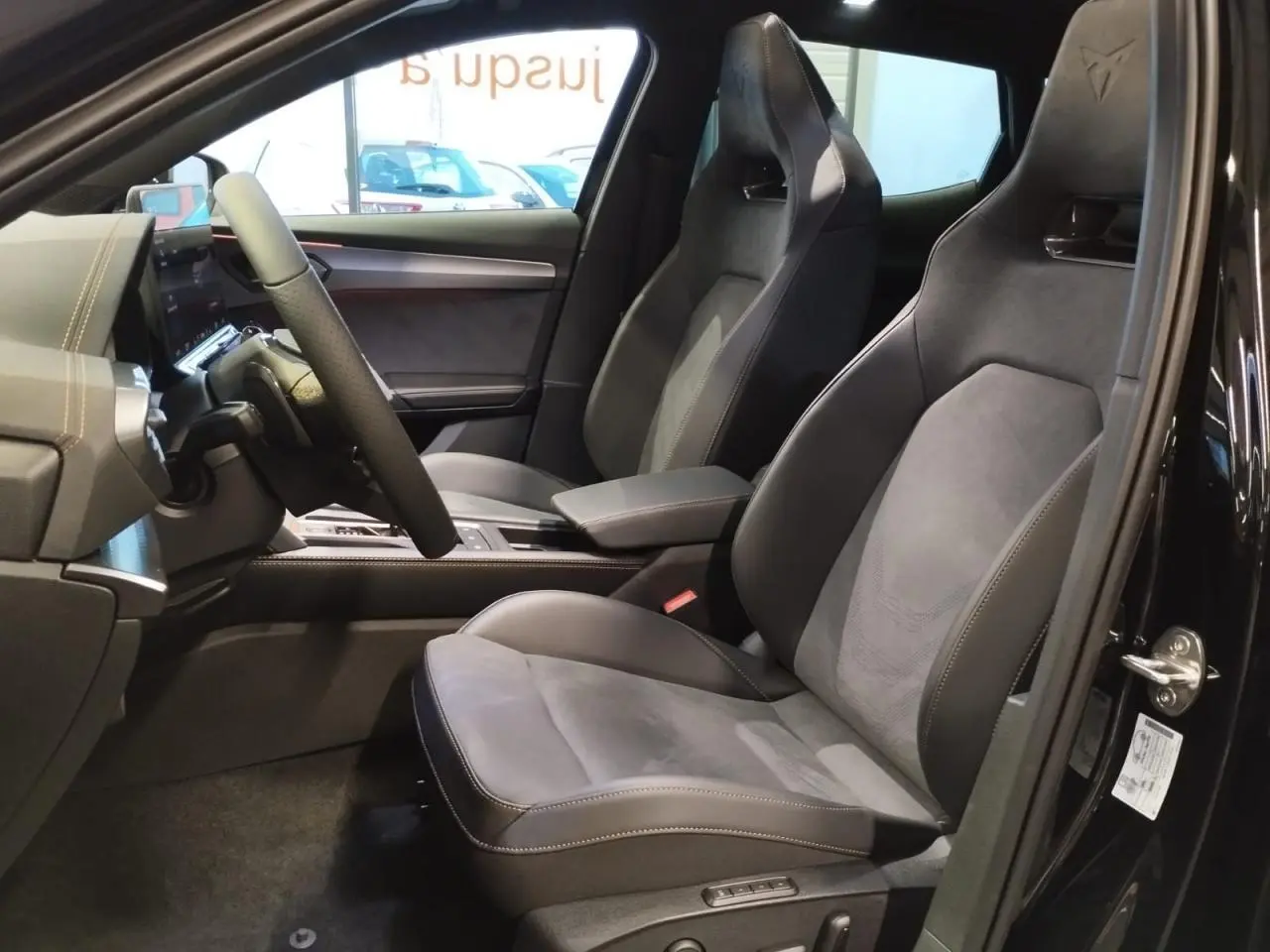 Vue intérieure côté conducteur du CUPRA Formentor noir métal 2026, sièges baquets suédine noire avec surpiqûres cuivrées.