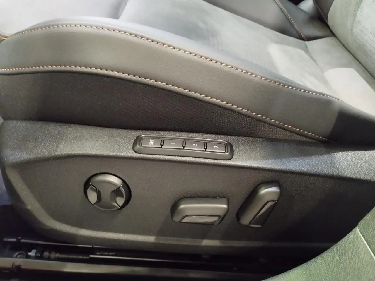 Détail du siège conducteur noir suédine avec réglages électriques et surpiqûres cuivrées dans une CUPRA Formentor noire.