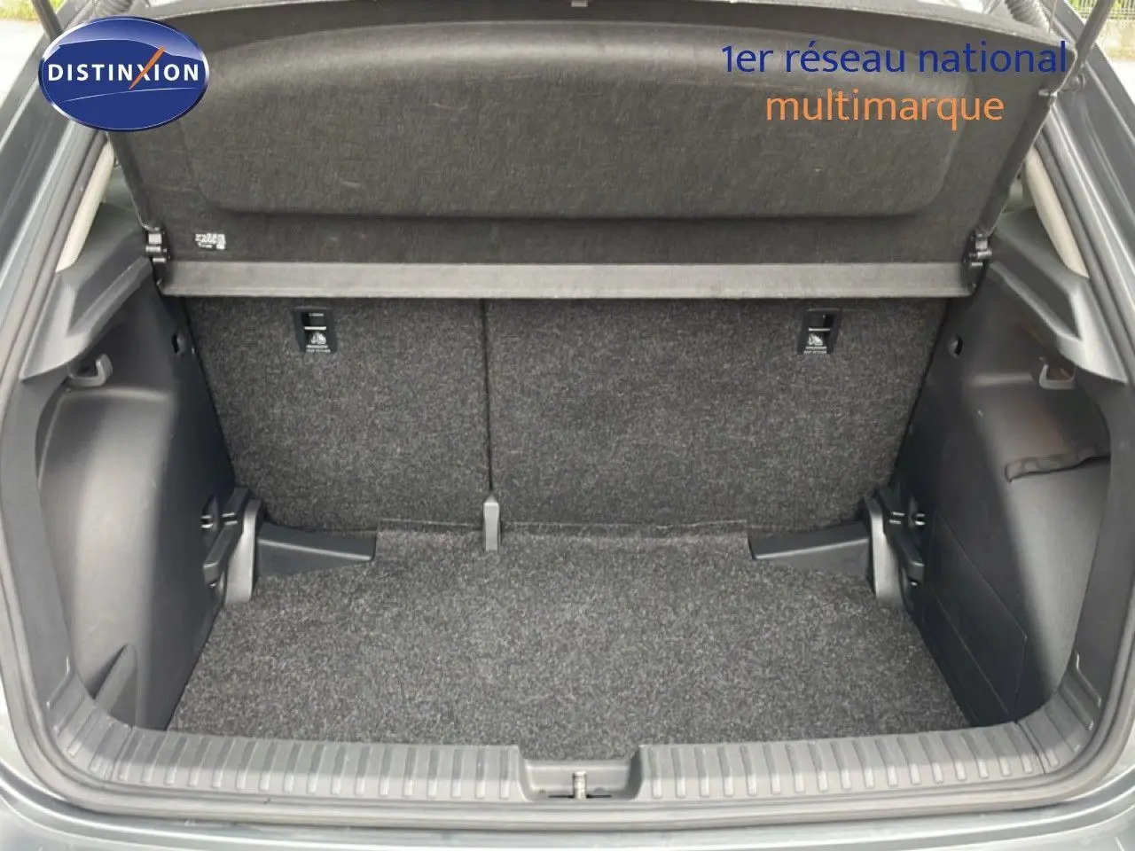 Coffre ouvert vu de l’arrière d’une Skoda Fabia gris graphite, montrant un espace de chargement propre et spacieux.