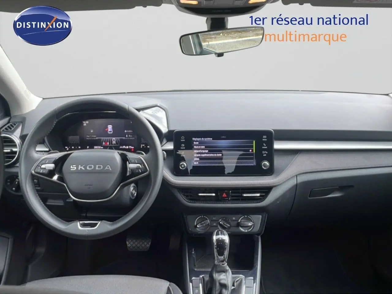 Intérieur de la Skoda Fabia 2025 en gris graphite, vue frontale du tableau de bord avec écran tactile et volant multifonction.