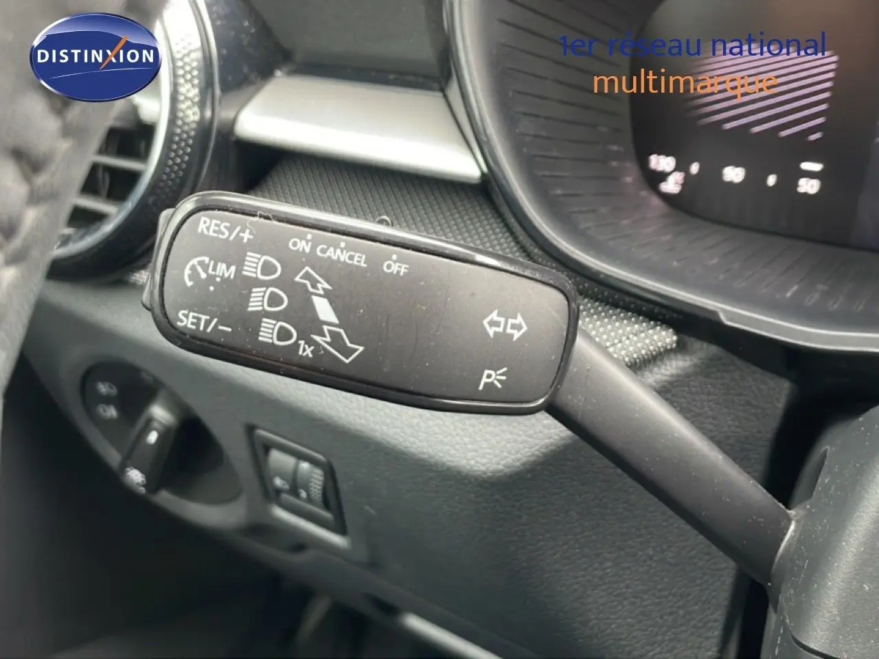 Gros plan sur la commande de régulateur de vitesse à gauche du volant dans l’habitacle gris noir d’une Skoda Fabia 2025.