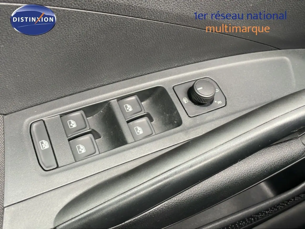 Gros plan sur les commandes de lève-vitres et réglage des rétroviseurs côté conducteur d'une Skoda Fabia gris graphite.