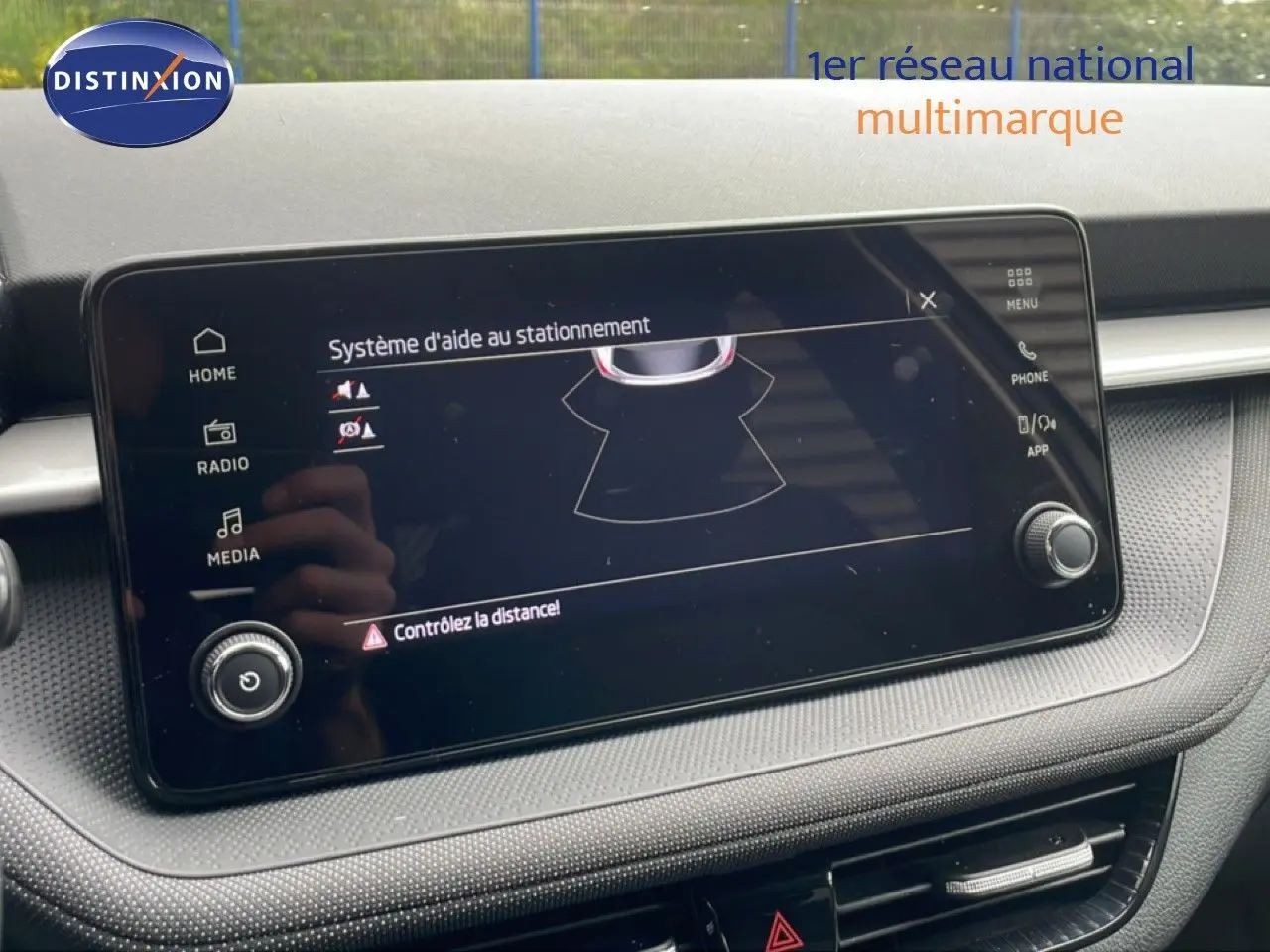 Écran tactile du système d'aide au stationnement dans l'habitacle gris noir de la Skoda Fabia 2025.