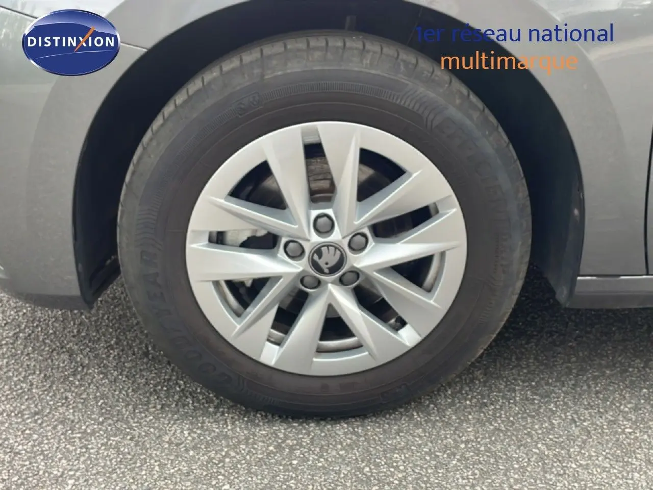 Gros plan sur la roue avant gauche d'une Skoda Fabia gris graphite métal avec jante alliage 15 pouces et logo central visible.