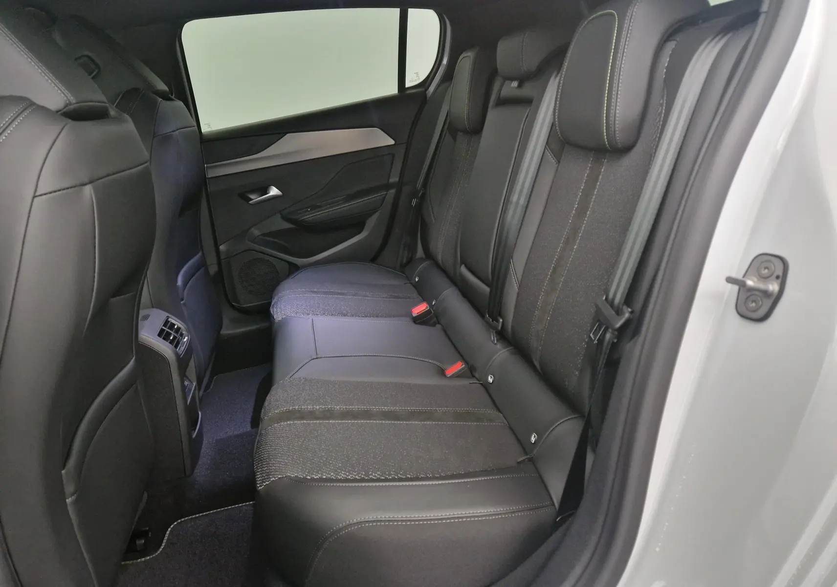 Vue intérieure côté droit des sièges arrière en tissu et cuir noir d'une Peugeot 308 blanche 2025 avec pack vision 360.