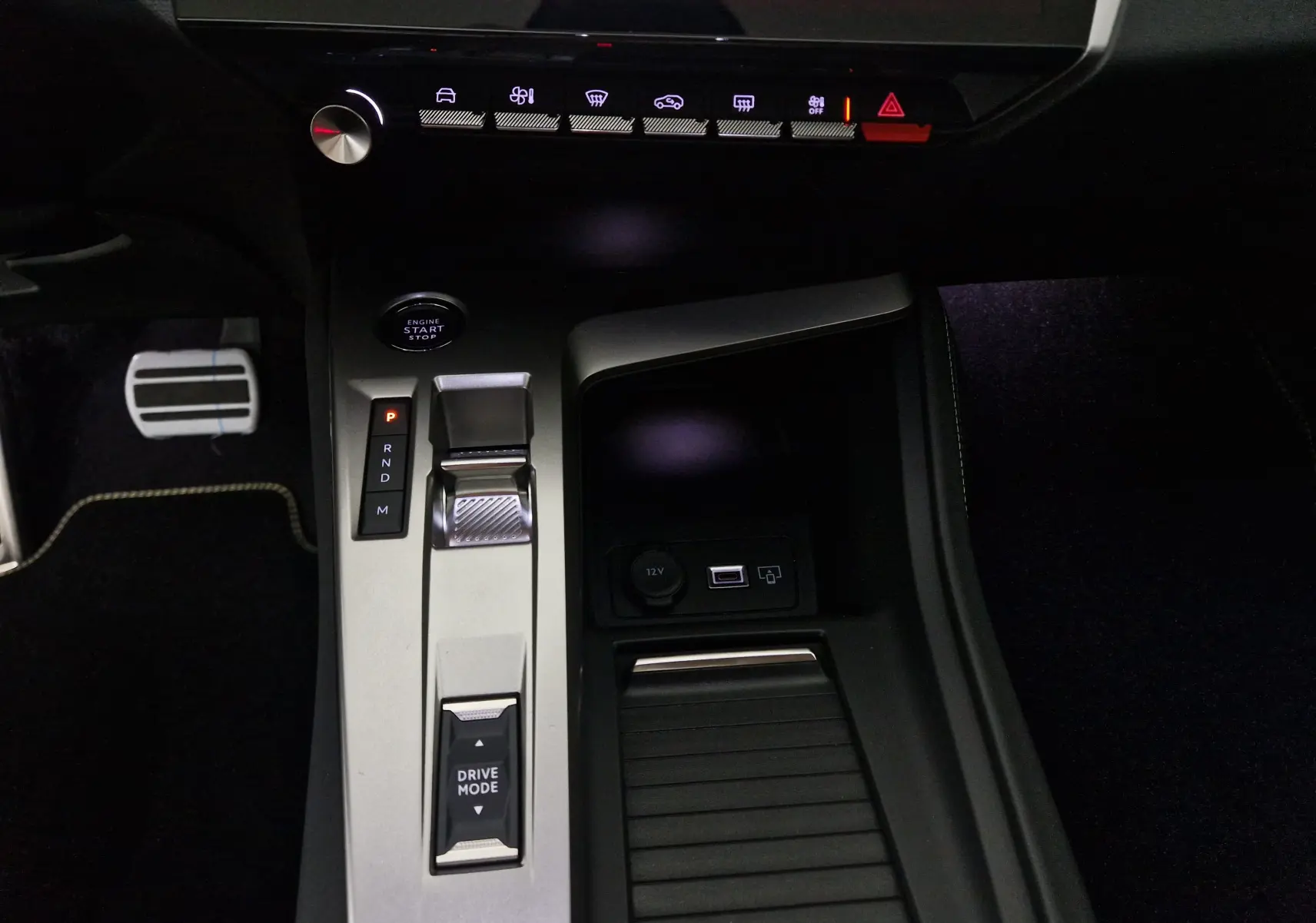Gros plan sur la console centrale de la Peugeot 308 blanche, montrant la commande de boîte auto et le bouton start/stop.